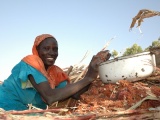 Khadidja shows the sorghum she got from her farm